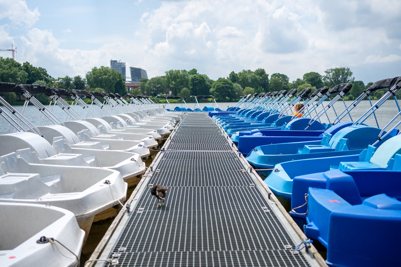 my-qualifications Blue and white paddleboats on a sunny day at a lake in Münster, Germany.