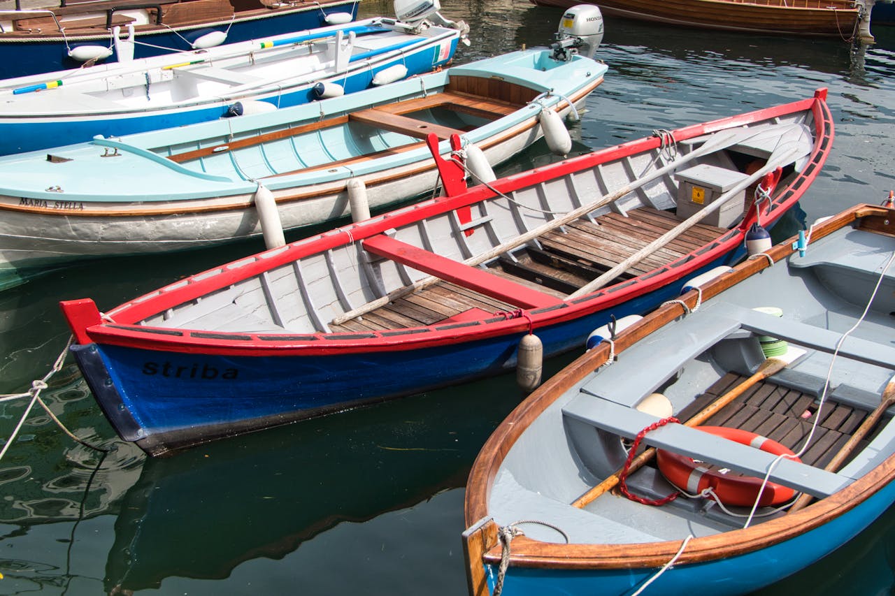 hero-img Vibrant wooden boats docked in Malcesine, Veneto, Italy, on a sunny day.