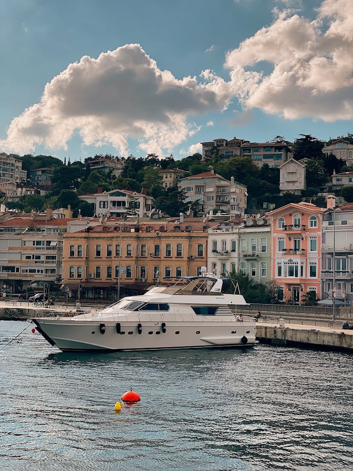 my-path Luxury yacht docked at a colorful waterfront, showcasing charming architecture under a partly cloudy sky.